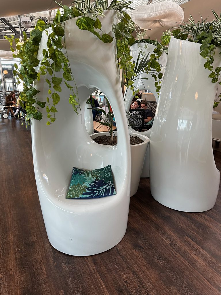 Impressive chic chairs in Nice Airport Lounge with plants growing out of the top
