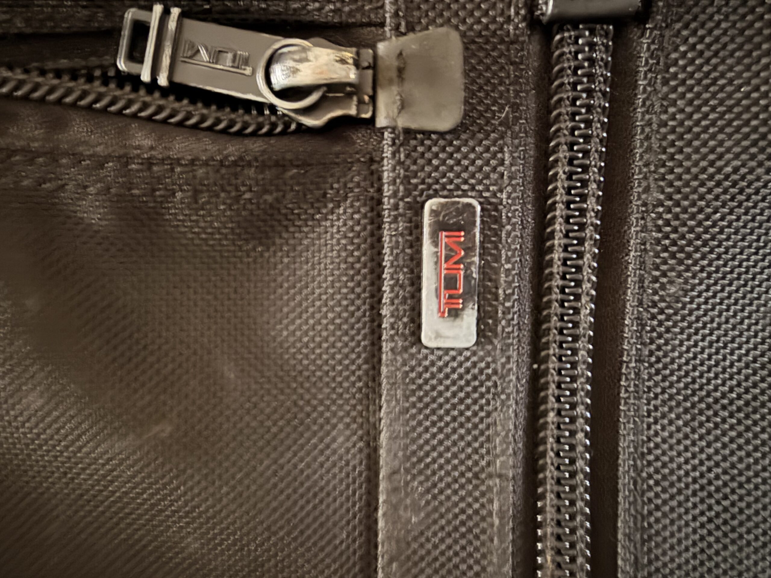 TUMI logo detail, well-used