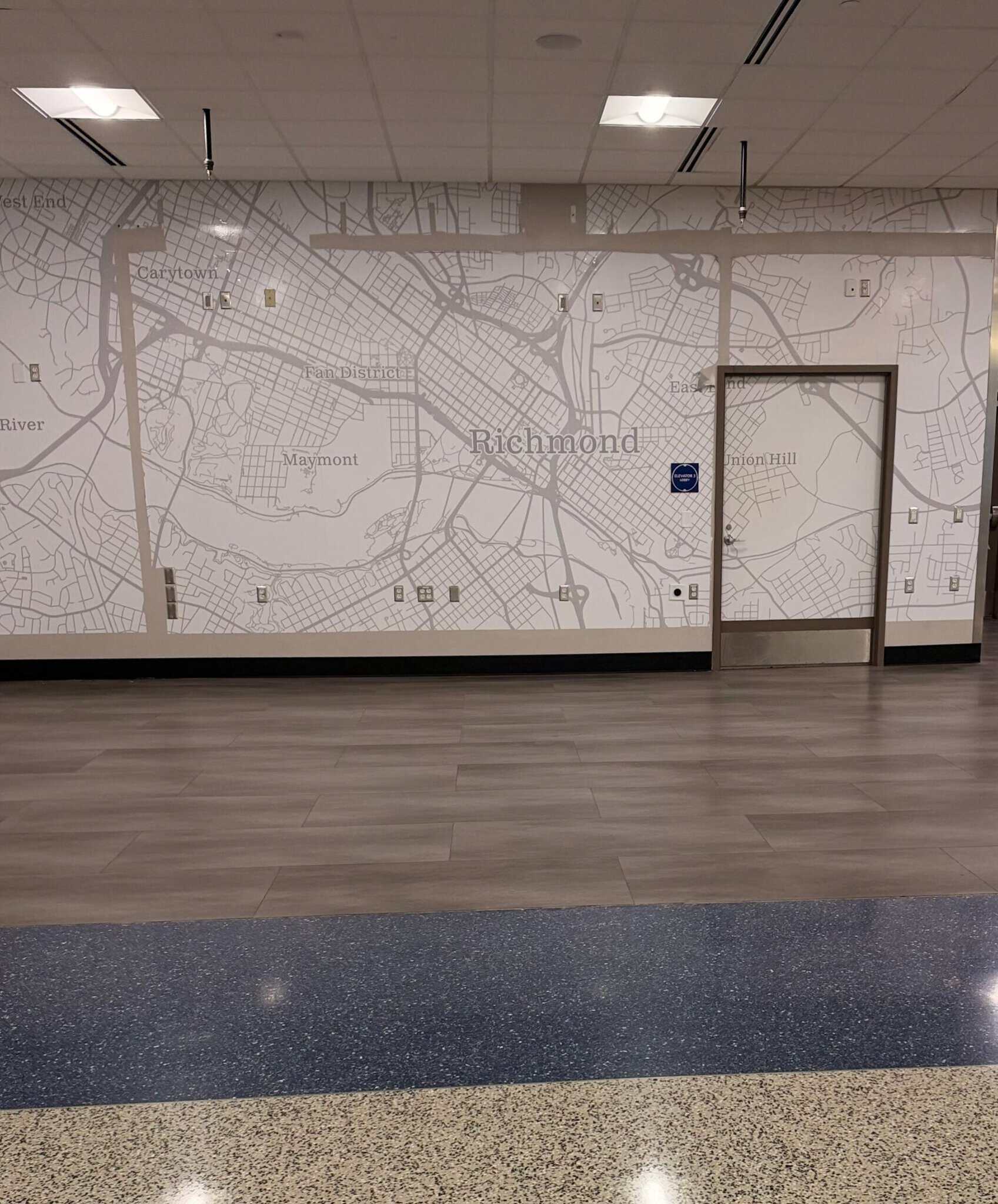 Wall-size street map mural of Richmond, Virginia inside RIC airport, labeling Carytown, Fan District, Maymont and Union Hill