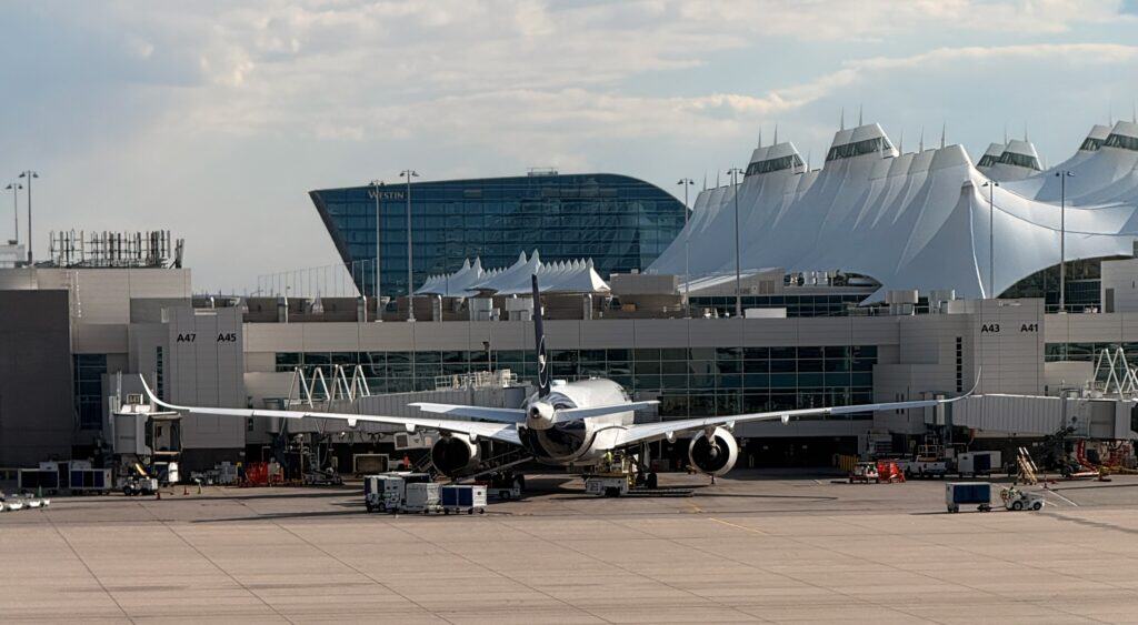 The Westin hotel visible above the DEN terminal tensile roof, with a jet at the gate - aviation photography by Anthony Yandow