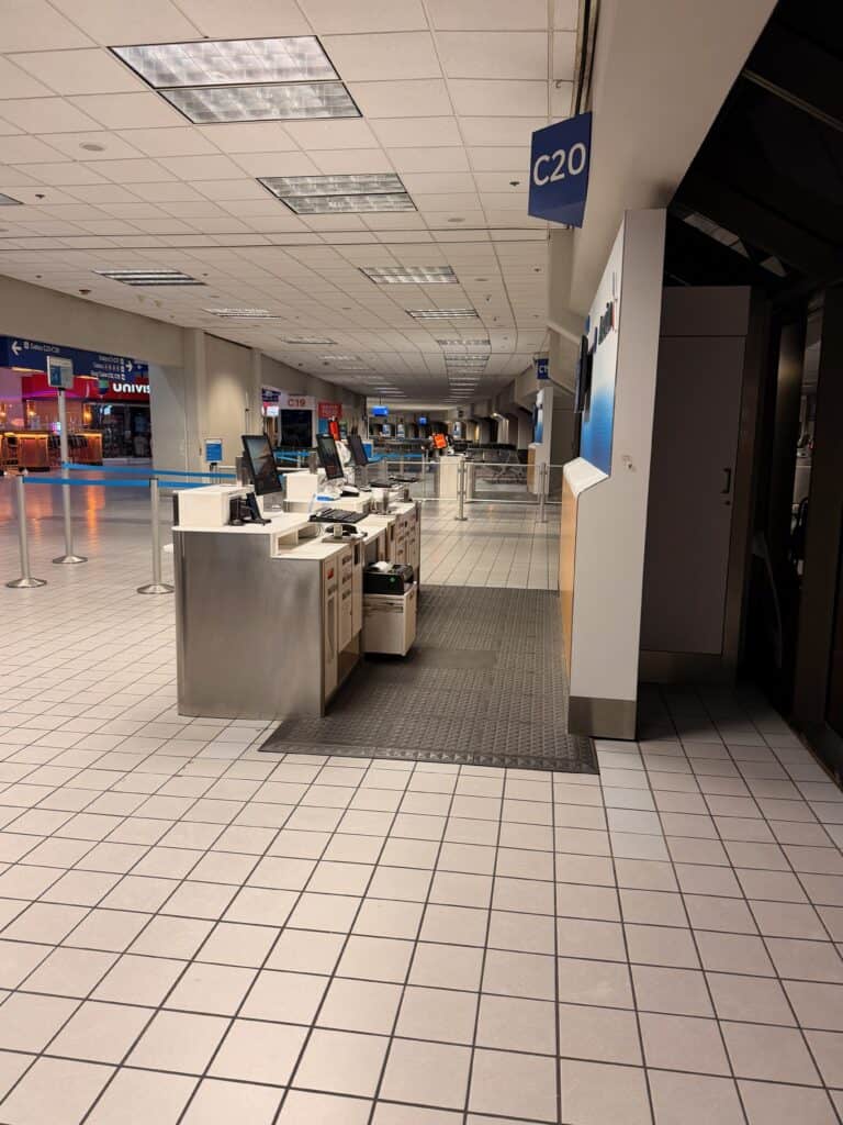 A dated gate check-in area at Gate C20 in DFW Terminal C with white tile floors and older fluorescent ceiling panels - aviation photography by Anthony Yandow