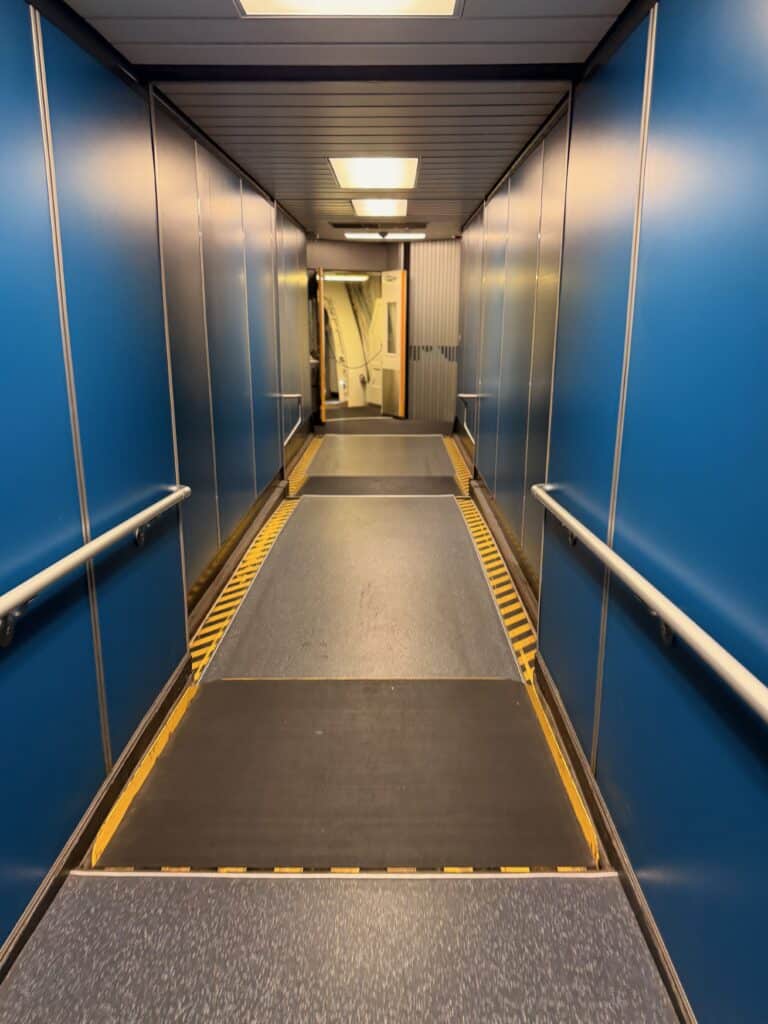 A windowless blue temporary jetway connector at LAX linking two construction-era terminal buildings - aviation photography by Anthony Yandow
