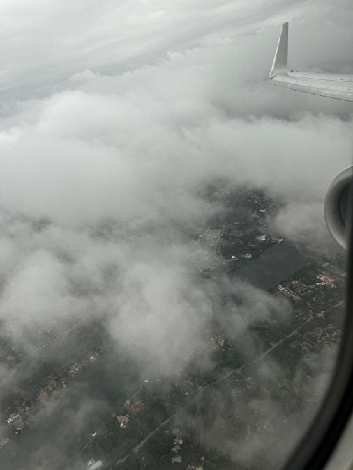 Is Extra Legroom Worth It? A Traveler's Honest Review Airplane wing above the clouds from a window seat on a long flight