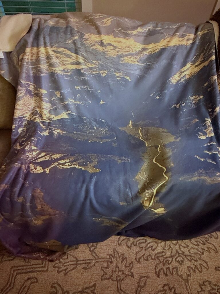 Giant sherpa fleece blanket printed with an aerial view of the Swiss Alps on a couch